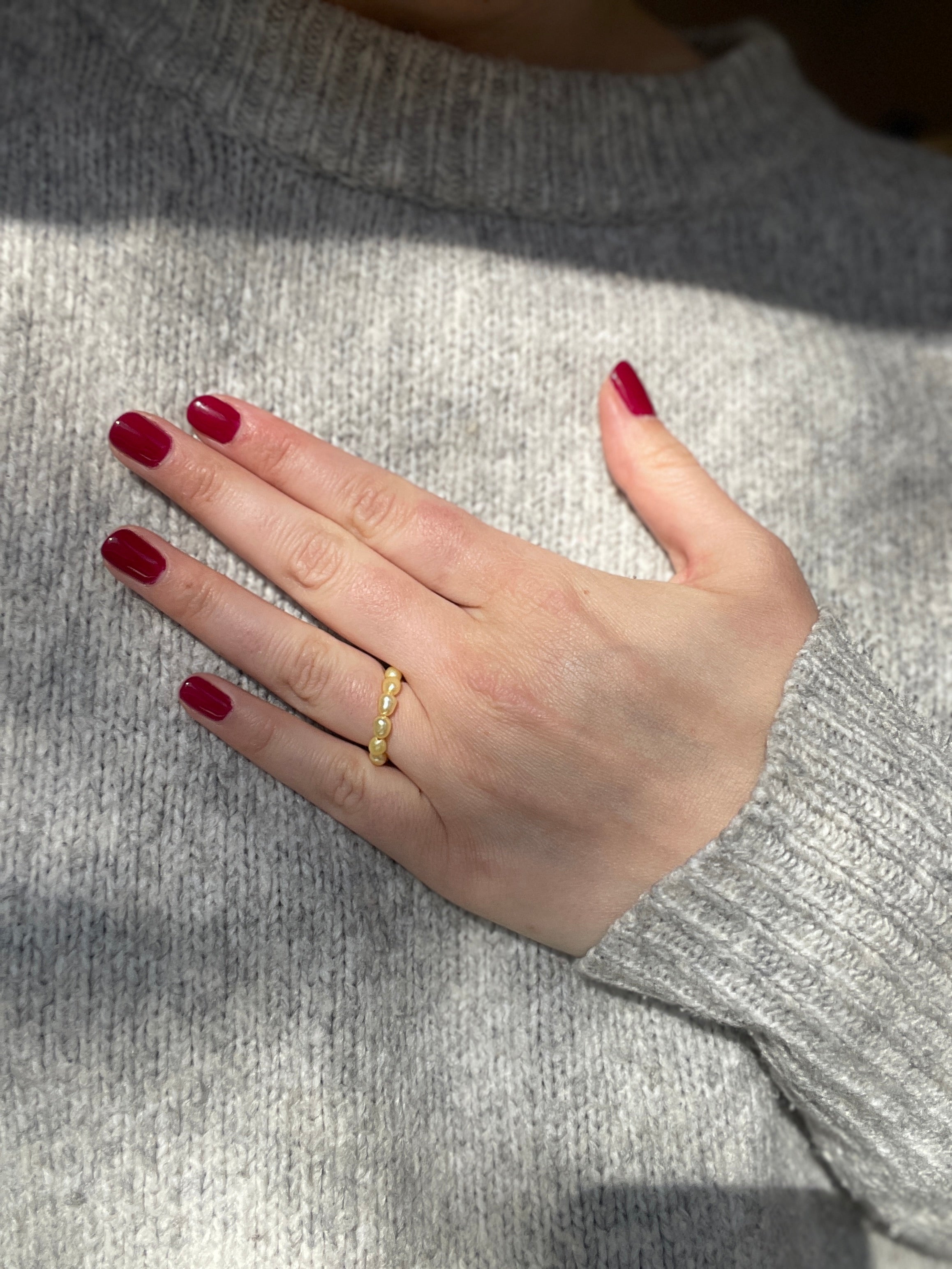Ring aus Perlen an Hand in gelb